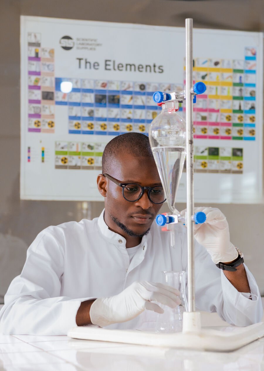 Fawase ADEGBINDIN manipulant du matériel de laboratoire de chimie