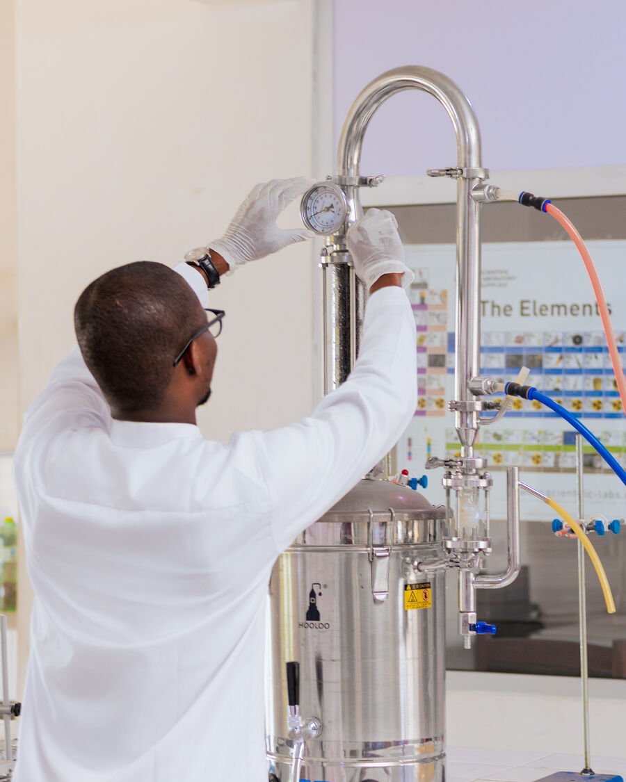 Fawase ADEGBINDIN en laboratoire, manipulant un appareil de distillation