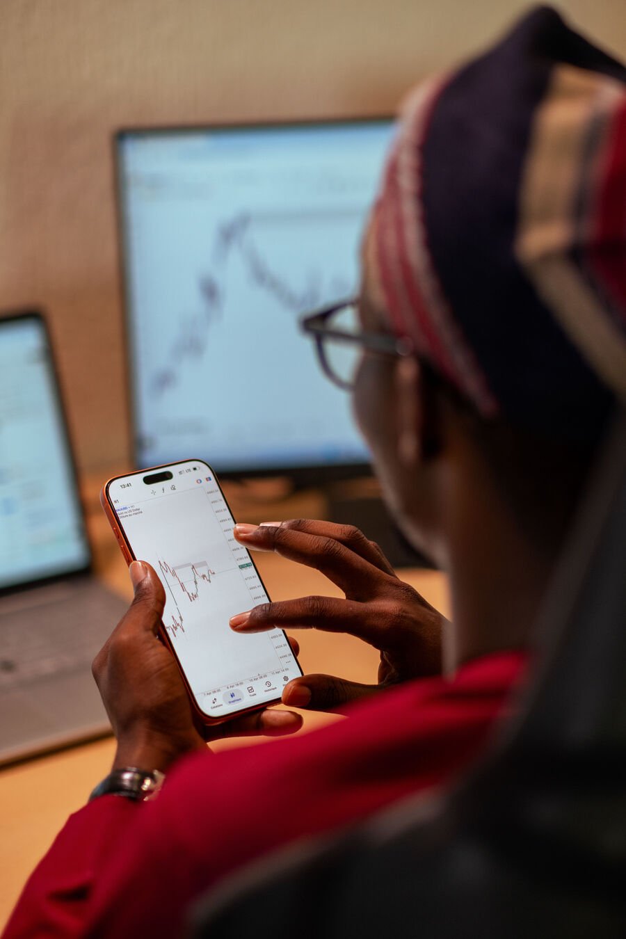 Fawase ADEGBINDIN consultant un graphique XAU/USD sur son téléphone